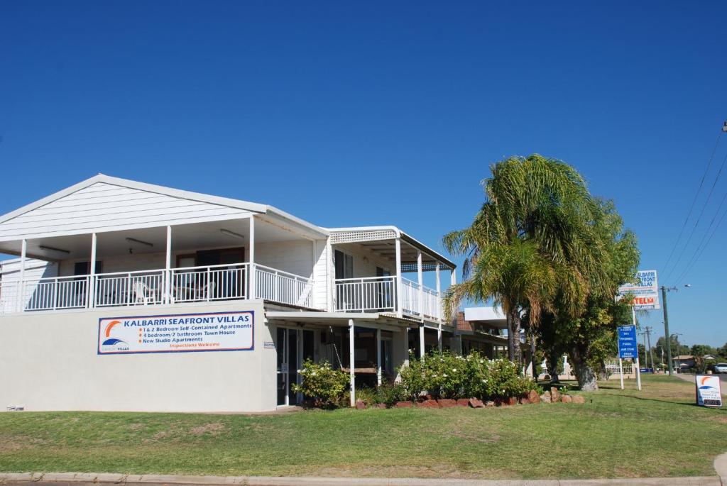 White coastal-style building with balcony at Kalbarri Seafront Villas on a clear sunny day.