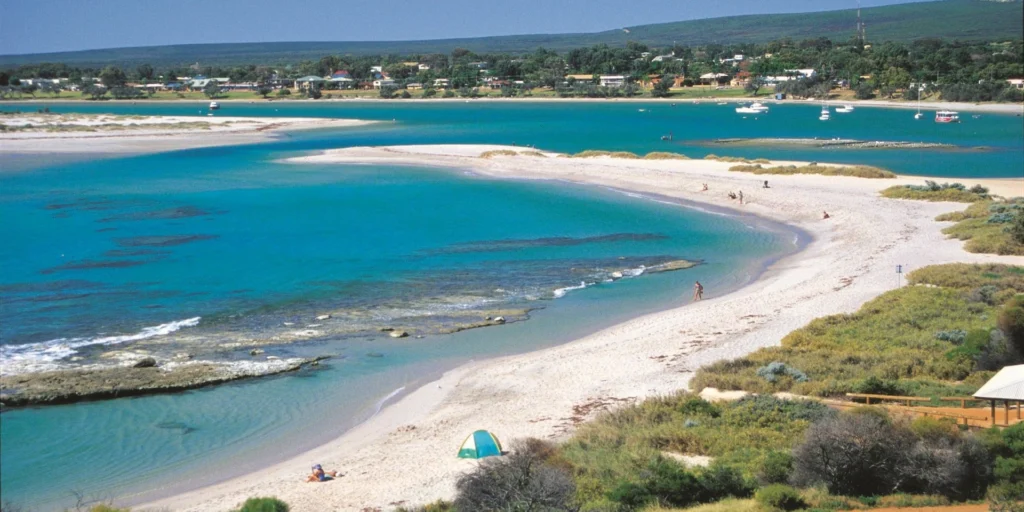 Aerial view of Chinaman’s Beach in Kalbarri showing turquoise water, white sand, and boats on the Murchison River estuary.